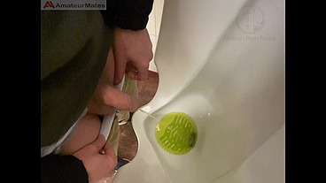 Amateur redhead guy caught pissing in a public toilet's urinal - he then quickly plays with his cock before leaving
