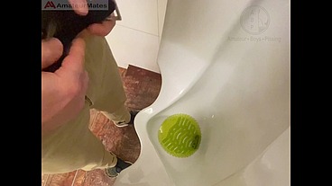Amateur redhead guy caught pissing in a public toilet's urinal - he then quickly plays with his cock before leaving