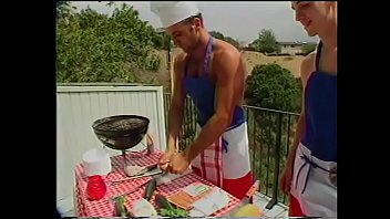 Young Gregg Clarke helps blond s.-hunter Paul Morgan to cook sausages and fish frames on barbeque grill