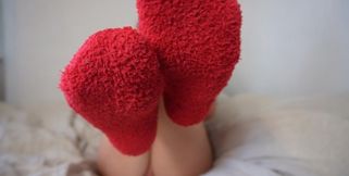 Showing off feet in fluffy Christmas socks and taking them off super close