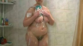 Chunky blonde cougar with hairy pussy and big breasts washes in the bathroom