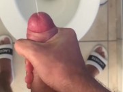 Cheeky guy jerks off a hairy dick in a toilet in sweatpants