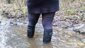 Black rubber boots and a deep stream