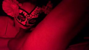 Masked in the red light sucking cock