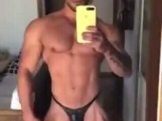 Guy in Black Posing Trunks In Front Of A Mirror