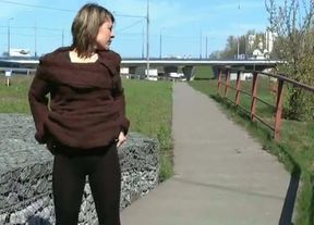 Nasty brunette beauty pisses near the highway on a sunny day