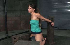 Cute white brunette in sexy dress is shackled to the post