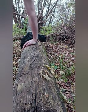 A young crossdresser in a cute outfit is impaled on a dildo and is riding it in the forest.