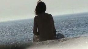 Naked girl caught sitting on the sandy beach all alone