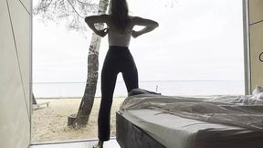 tanned temptress bends in ocean breeze