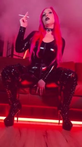 Pink haired Luvie Doll smoking EVE 120s cigarette in a PVC catsuit looking like the devil with nails