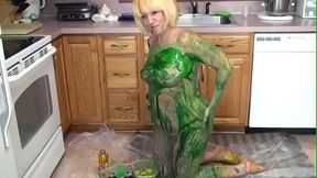 Blonde in kitchen rubs green paint over her tits and ass