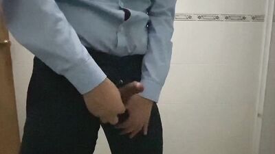 Horny chap is stroking his cock in the public bathroom
