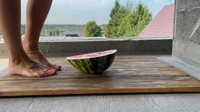 Beautiful feet crushed a watermelon