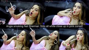 Angie smoking Nat Sherman 164s all white close up in pink corset!