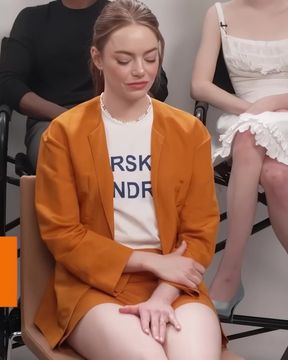 Famous redhead Emma Stone shows off her slim figure while sitting