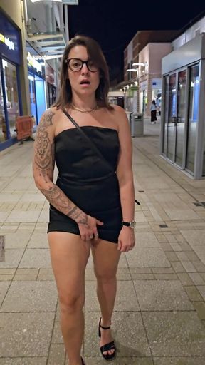 Woman in black dress walking down street