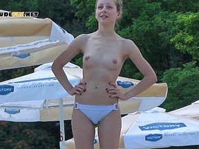 Playful young nudis girlt has fun at the beach