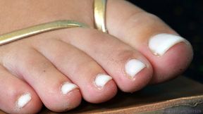 Foot and sandals fetish admiration series, feet close-up, dirty toes and white polish nails