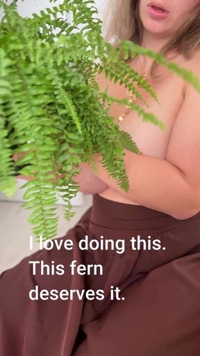 My wife looks wonderful with her bare breasts next to her fern.