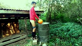 Teenager is hard drilling a pumpkin in the garden