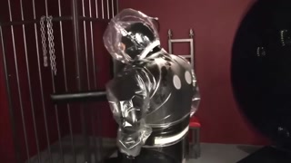 Blonde girl in black latex catsuit full encased in inflatable rubber and full body plastic suit