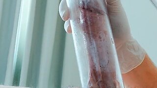 Putting on latex medical gloves while pumping a penis