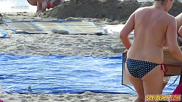 Topless ladies are enjoying on the beach even while guys are staring at their tits