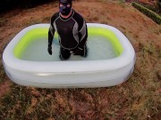 Rufus pawing off in wetsuit, fins and pool