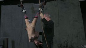 Grey haired master ties up hands of hanging upside down brunette hoe