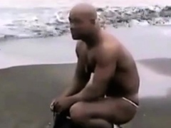 Asian bodybuilder barely covered at the beach