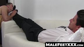 Handsome suited guy enjoys feet massage and toe sucking