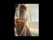 Nia Nebula poses in front of her DC hotel window while enjoying a glass of champagne
