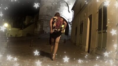 Old tranny is walking across the city and posing for the camera