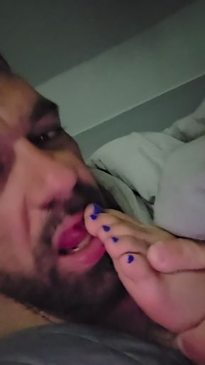 Sucking her toes while she watches a movie