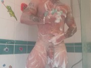 Muscular tattooed guy takes hot shower after the gym