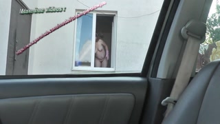 Outside the house naked woman on the street. The taxi driver saw a naked woman cleaning the window of the apartment. Public