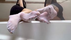 Daniitrix and priifee showing nylon stockings on their legs and applying oil