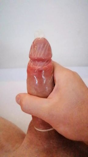 Boy masturbating his dick until cumshot in condom