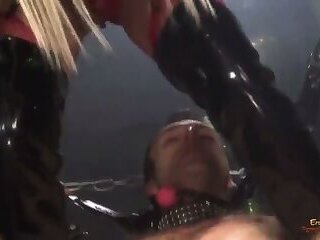 Slutty blonde MILF in a red latex outfit bound and gagged a handsome guy before sucking and riding