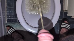 Man with fat belly pissing in the toilet