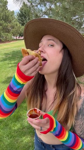 Woman eating pizza in park