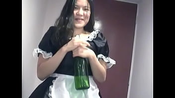 Young Asian girl dressed as a maid indulges herself with a bottle of on camera for you