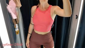 A girl with a perfect figure shows her breasts in a fitting room