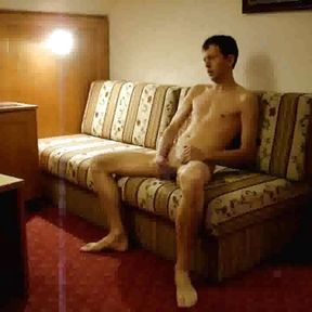 Naked twink strokes his cock in a hotel room