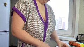 The MILF is cooking soup and showing off her breasts.