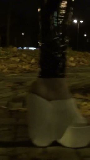 crossdresser walks on the street in latex leggings and very high white wedges   Clip 1