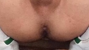 Naked twink tastes his cum after wanking smooth cock with tight little balls, wearing only cap, socks, and sneakers.