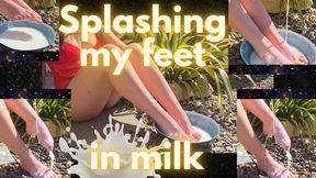 Sitting outdoors in lingerie, i pour milk over my feet, splashing it and letting it run off my toes