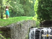 Sexy babe pees near a waterfall